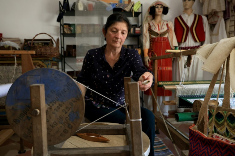 Mimoza Pjetraj travaille sur un métier à tisser avec des fils de soie dans son atelier du village de Dajc, dans la région de Zadrima, le 27 mai 2025 en Albanie ( AFP / Adnan Beci )