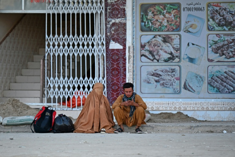 Un Afghan et une femme en burqa sur un marché dans le district de Spin Boldak, dans la province de Kandahar, en Afghanistan, le 15 septembre 2026 ( AFP / Sanaullah SEIAM )