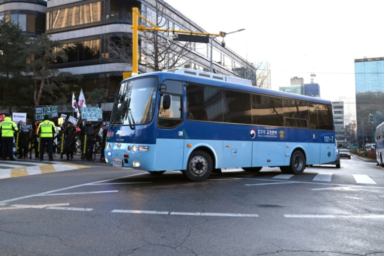 Un bus, transportant vraisemblablement l'ancien président sud-coréen destitué Yoon Suk Yeol, arrive au tribunal du district central de Séoul où doit se tenir son procès final pour insurrection, le 13 janvier 2026  ( AFP / Jung Yeon-je )