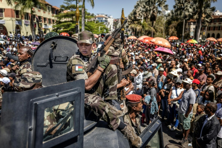Des membres de l'unité militaire Capsat patrouillent à bord d'un véhicule blindé alors que les habitants se rassemblent pour une cérémonie en hommage aux manifestants tués lors des manifestations antigouvernementales à Antananarivo, le 12 octobre 2025 à Madagascar ( AFP / Luis TATO )