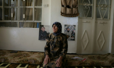 Fatima al-Safadi se tient dans sa maison à côté des portraits de ses deux fils détenus par Israël, le 29 avril 2026 à Beit Jinn dans le sud de la Syrie  ( AFP / Bakr ALkasem )