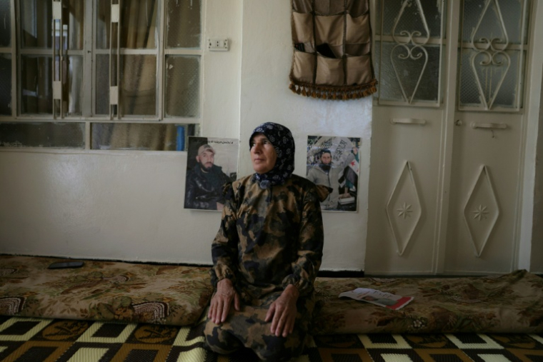 Fatima al-Safadi se tient dans sa maison à côté des portraits de ses deux fils détenus par Israël, le 29 avril 2026 à Beit Jinn dans le sud de la Syrie  ( AFP / Bakr ALkasem )