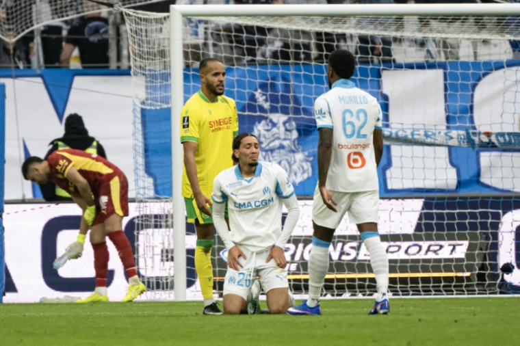 Le joueur de l'Olympique de Marseille Bilal Nadi, à genoux, reçoit un carton rouge lors de la débacle de l'OM en L1 contre Nantes le 4 janvier 2026 au Stade Vélodrome ( AFP / MIGUEL MEDINA )