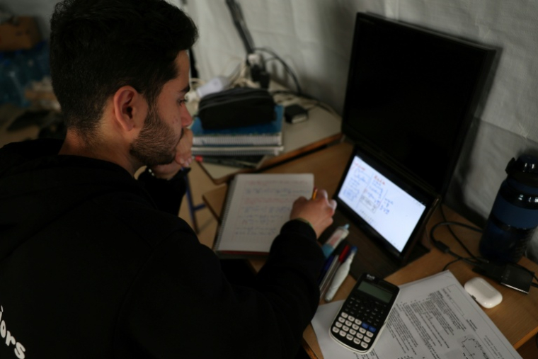 Un jeune homme poursuit ses études en ligne dans une école publique transformée en refuge pour personnes déplacées, à Dekwaneh, au nord de Beyrouth, le 25 mars 2026 au Liban ( AFP / Anwar AMRO )