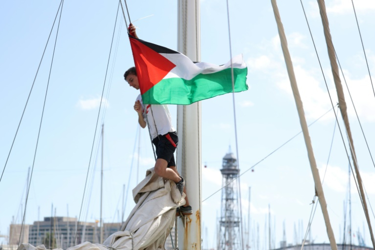 Un militant place un drapeau palestinien sur l'un des bateaux de la flotille d'aide humanitaire qui se prépare à partir pour Gaza depuis Barcelone, le 30 août 2025 ( AFP / LLUIS GENE )