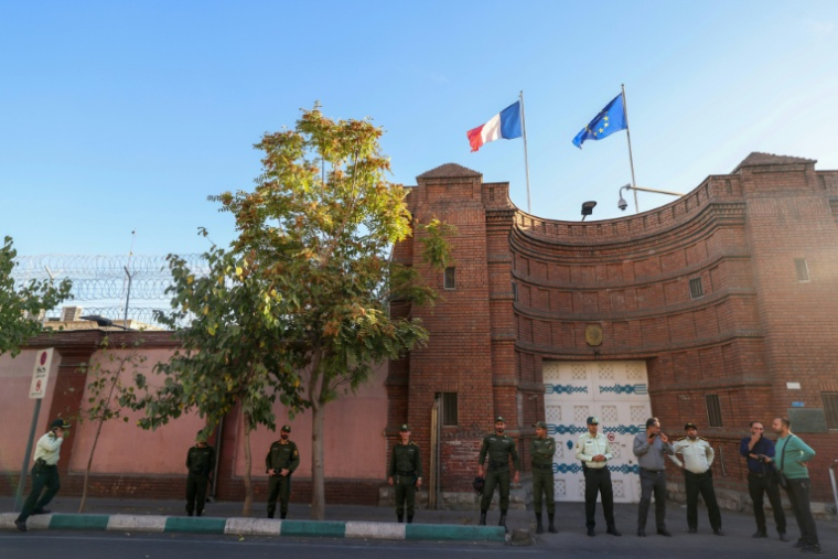 Des membres des forces de sécurité iraniennes montent la garde devant l'ambassade de France à Téhéran, le 21 octobre 2025, lors d'une manifestation de soutien à l'Iranienne Mahdieh Esfandiari,  arrêtée en France ( AFP / ATTA KENARE )