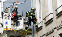Des pompiers utilisent une grue pour rechercher  deux collègues portés disparus après avoir été ensevelis sous les décombres en éteignant un incendie dans un immeuble à Laon, le 10 juin 2025 dans l'Aisne ( AFP / Francois LO PRESTI )