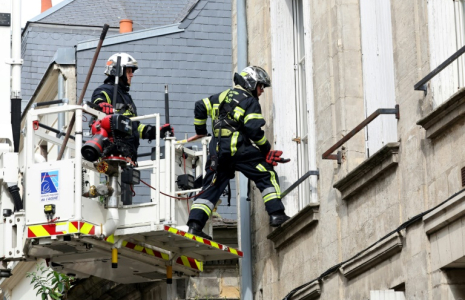 Des pompiers utilisent une grue pour rechercher  deux collègues portés disparus après avoir été ensevelis sous les décombres en éteignant un incendie dans un immeuble à Laon, le 10 juin 2025 dans l'Aisne ( AFP / Francois LO PRESTI )