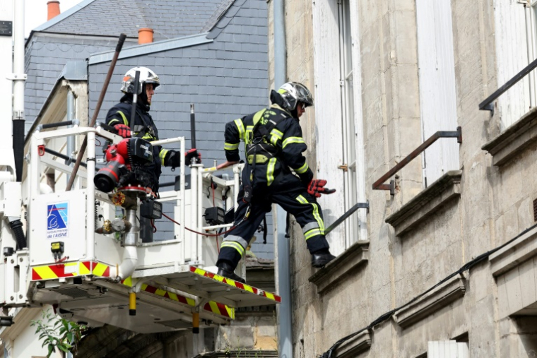 Des pompiers utilisent une grue pour rechercher deux collègues portés disparus après avoir été ensevelis sous les décombres en éteignant un incendie dans un immeuble à Laon, le 10 juin 2025 dans l'Aisne ( AFP / Francois LO PRESTI )
