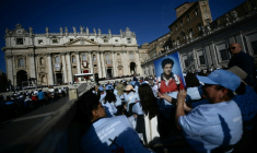 A faithful holds a portrait of late teenager Carlo Acutis in front of Saint Peter's Basilica ahead of a Holy Mass and canonisation ceremony of Blessed Carlo Acutis and Pier Giorgio Frassati in St Peter's Square at the Vatican on September 7, 2025. An Italian teenager dubbed "God's Influencer" for his efforts to spread the Catholic faith online will become the first millennial saint Sunday at a canonisation attended by thousands of pilgrims. Computer whiz Carlo Acutis, who died of leukemia in 2006 aged 15, will be raised to sainthood by Pope Leo XIV in a solemn ceremony in St Peter's Square at the Vatican. Italian Pier Giorgio Frassati, a mountaineering enthusiast who died in 1925 and was known for his social and spiritual commitment, will also be made a saint on September 7, 2025. ( AFP / Filippo MONTEFORTE )