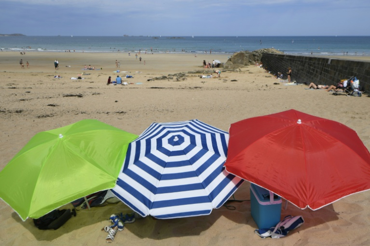 Trois parasols sur la plage de Saint-Malo, lors d'une vague de chaleur le 18 juillet 2018, en Ille-et-Vilaine ( AFP / DAMIEN MEYER )