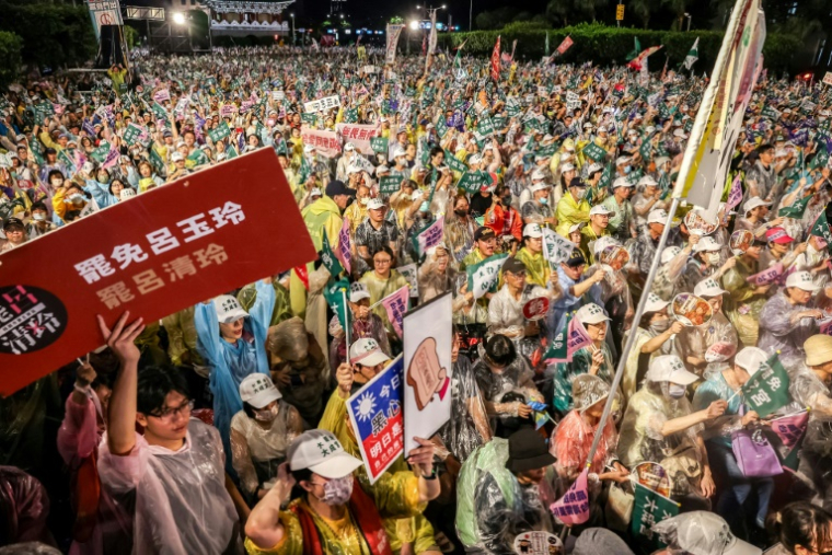 Des manifestants pro-destitution devant le palais présidentiel à Taipei sous une pluie torrentielle, le 24 juillet 2025 ( AFP / I-Hwa CHENG )