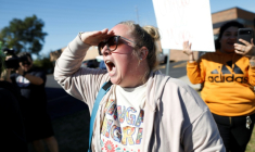 Une manifestante, Kate Madrigal, devant un centre de la police de l'immigration américaine (ICE) en banlieue de Chicago, le 9 octobre 2025 ( AFP / OCTAVIO JONES )