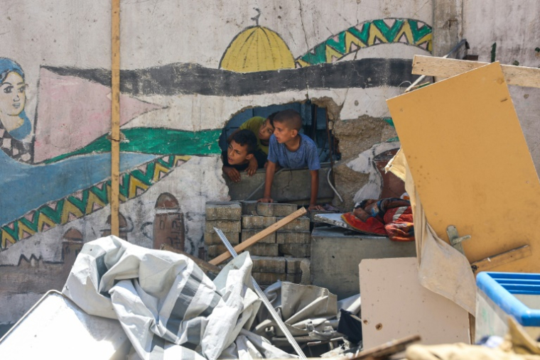 Des enfants constatent les dégats après le bombardement de l'école Mustafa Hafez, le 3 juillet 2025 à Gaza-ville ( AFP / Omar AL-QATTAA )