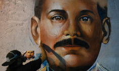 Le graffeur Wolfgang Salazar, alias Badsura, met la touche finale à un portrait du médecin vénézuélien Jose Gregorio Hernandez sur un mur de Caracas, le 27 avril 2021 ( AFP / Federico PARRA )