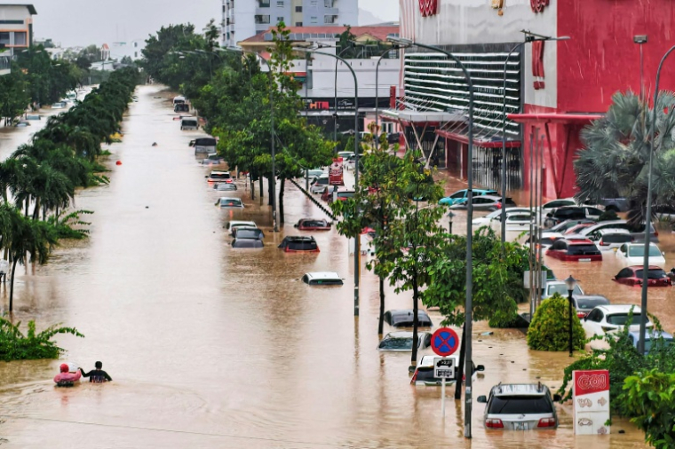 Des personnes traversent une rue inondée de Nha Trang au Vietnam le 20 novembre 2025 ( AFP / Duc Thao )