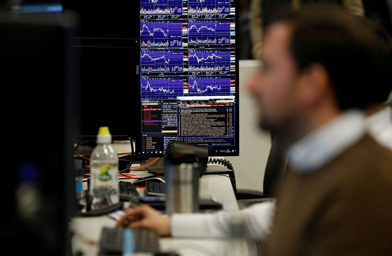 Des traders travaillent chez CMC Markets dans la City de Londres